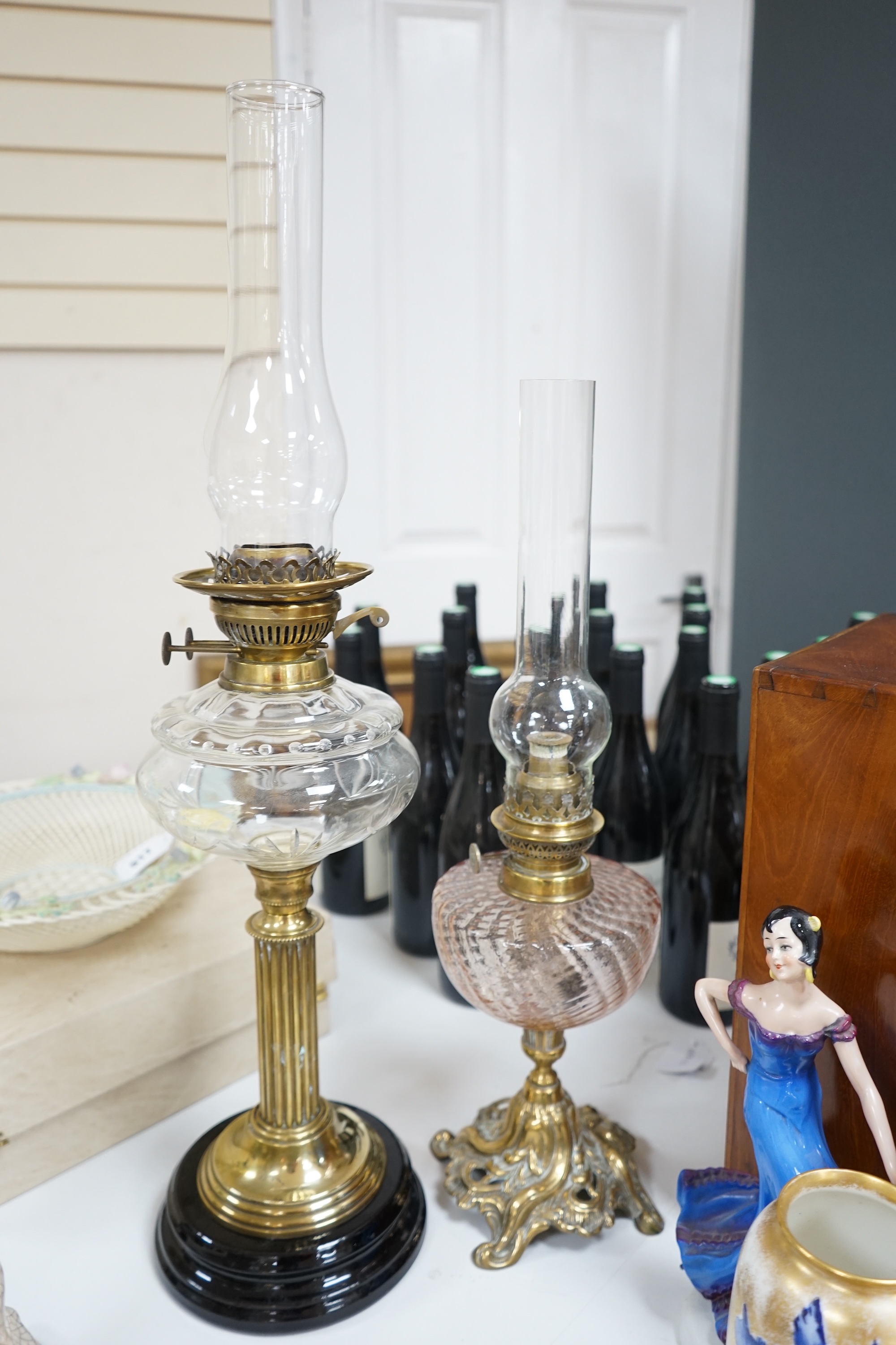 Two brass oil lamps with glass spirit tanks, tallest 67cm. Condition - good.